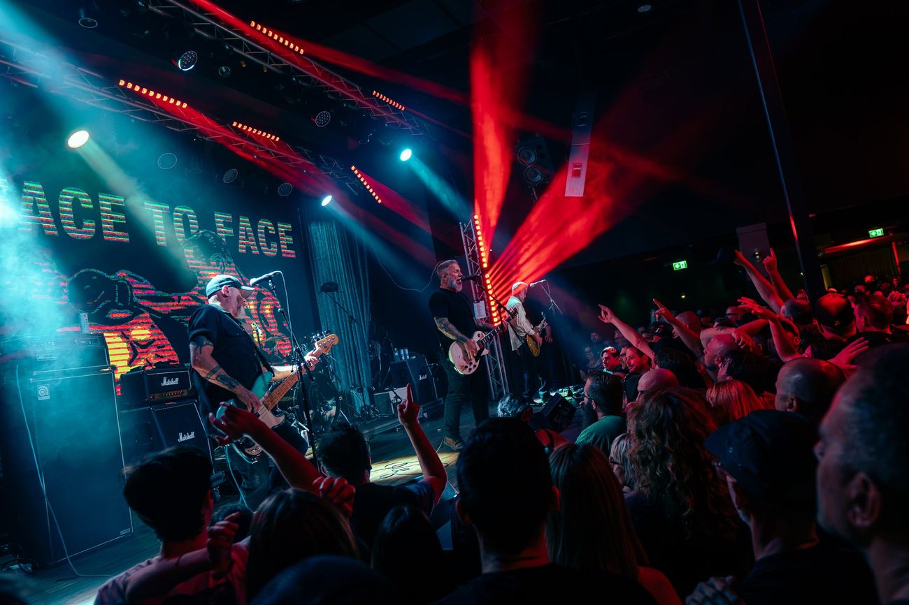 Band on stage under red and teal lights